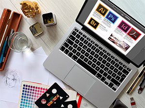Laptop auf dessen Bildschirm die Programmicons von Adobe Illustrator, PhotoShop, InDesign, Acrobat und Bridge zu sehen sind – Adobe Creative Cloud Schulung