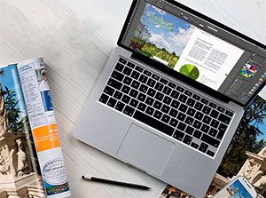 Laptop auf dessen Bildschirm ein Magazinlayout in Adobe InDesign zu sehen ist – Adobe InDesign Schulung